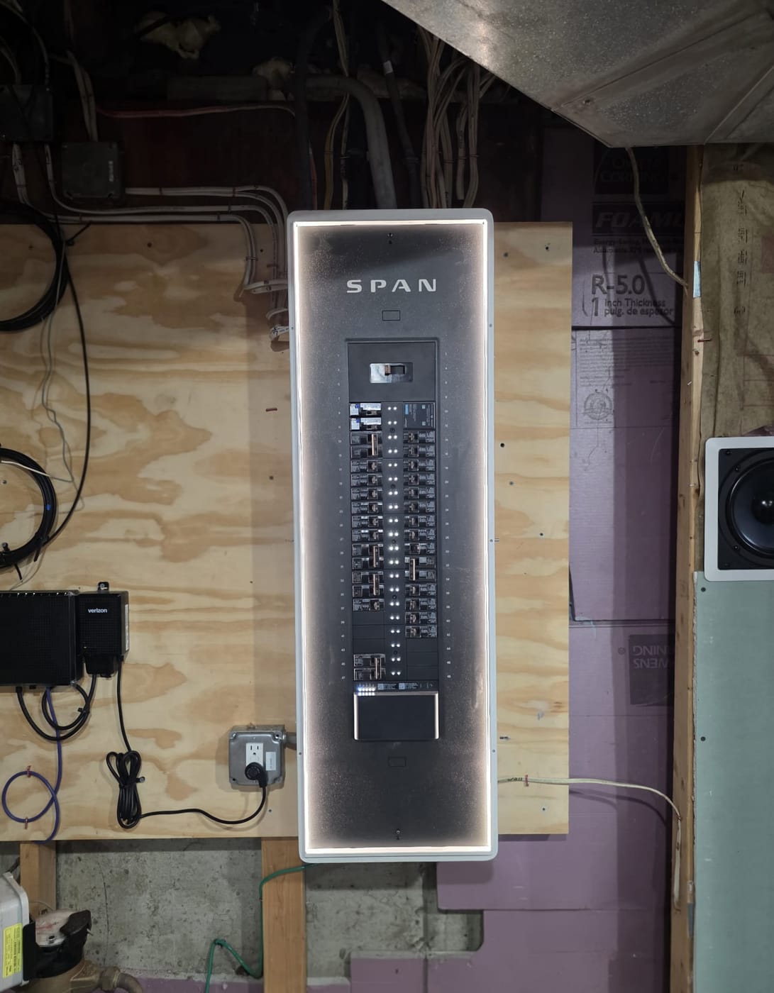 SPAN smart panel installed by Powered Up LLC, backlit and open to show the breaker layout