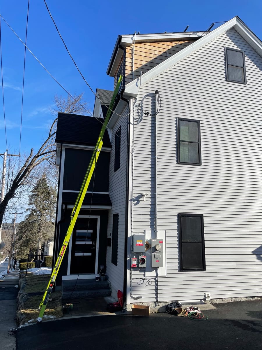 200A electrical service upgrade installation on a white South Shore home